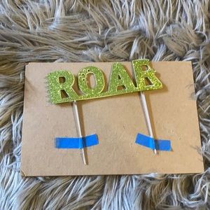 New, unused ROAR cake topper